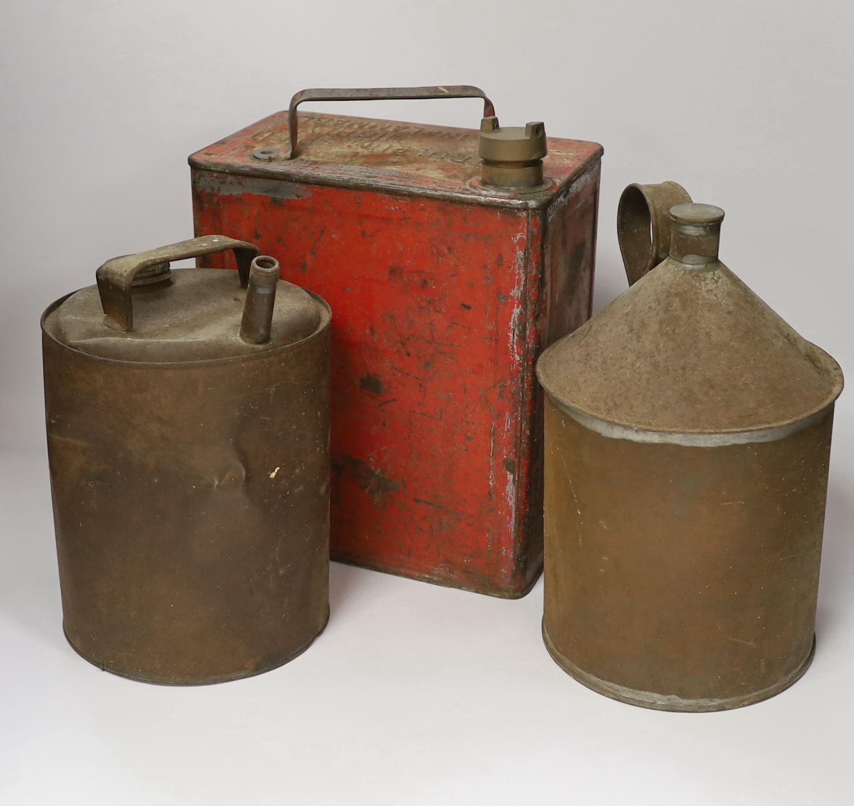 A 20th century red petrol can and two others, largest 32cm high